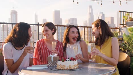 Retrato-de-mujer-amigos-celebrando-el-cumpleaños-en-la-terraza-de-la-azotea-con-el-horizonte-de-la-ciudad-en-segundo-plano