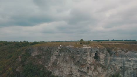 Young-and-beautiful-wedding-couple-together-on-the-slope-of-the-mountain-near-sea.-Lovely-groom-and-bride.-Shooting-from-the-air.-Aerial-shot