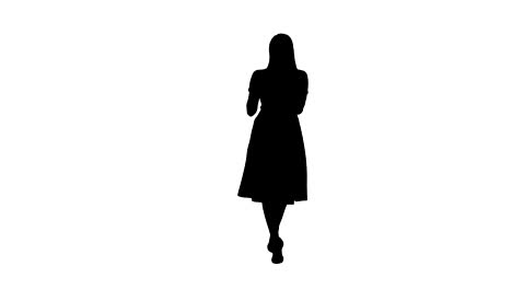 Silhouette-Smiling-woman-in-pink-dress-doing-making-video-call-and-walking