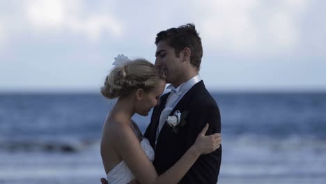 Linda-recién-casados-par-abrazar-en-la-playa