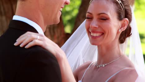 Joven-pareja-de-recién-casados-bailar-juntos-y-sonriendo-a-la-cámara