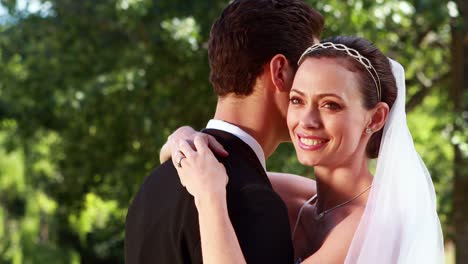 Smiling-bride-embracing-her-new-husband