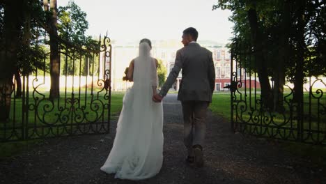 Newlyweds-are-moving-towards-a-mansion-in-a-park.