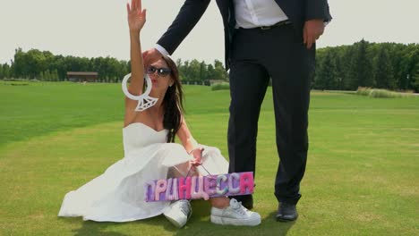 Bride-sitting-on-green-grass.