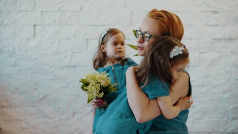 Mother-and-two-little-daughters-are-hugging-each-other