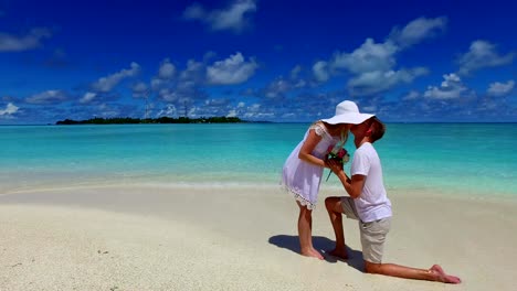 v07387-Maldives-white-sandy-beach-2-people-young-couple-man-woman-proposal-engagement-wedding-marriage-on-sunny-tropical-paradise-island-with-aqua-blue-sky-sea-water-ocean-4k