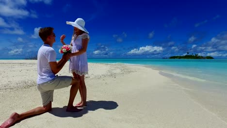 v07385-Maldives-white-sandy-beach-2-people-young-couple-man-woman-proposal-engagement-wedding-marriage-on-sunny-tropical-paradise-island-with-aqua-blue-sky-sea-water-ocean-4k