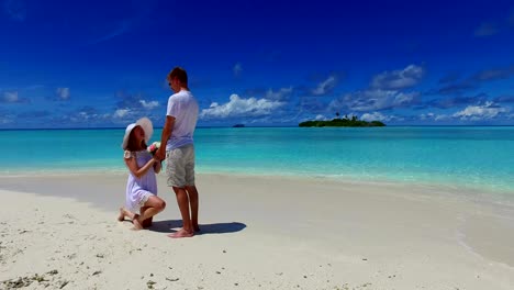 v07389-Maldivas-playa-2-personas-joven-pareja-hombre-matrimonio-mujer-propuesta-compromiso-boda-isla-paraíso-soleado-con-cielo-azul-aqua-agua-mar-4k