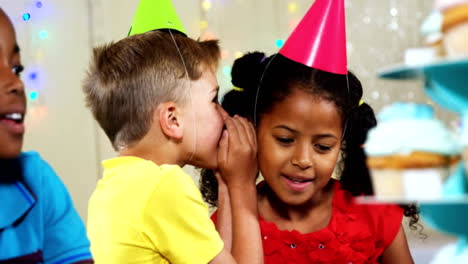 Niño-susurrando-a-chica-sentado-con-amigos-en-cumpleaños-partido-4k