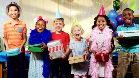 Portrait-of-kids-holding-gift-boxes-during-birthday-party-4k