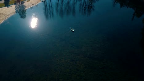 Jóvenes-novios-nadando-a-bordo-en-el-lago-hermoso.-Vista-aérea