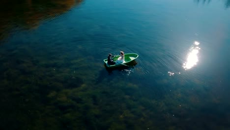 Jóvenes-novios-nadando-a-bordo-en-el-lago-hermoso.-Vista-aérea