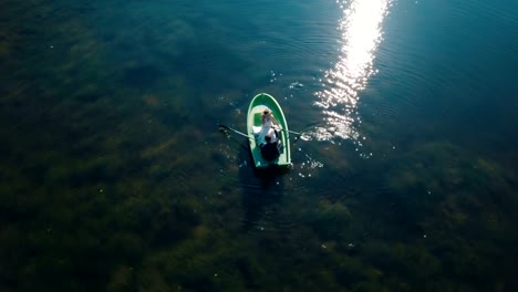 Young-wedding-couple-swimming-on-board-in-beautiful-lake.-Aerial-view