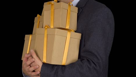 Caucasian-man-in-classic-suit-stand-and-hold-many-gift-boxes.-Brown-gift-box.-Businessman-present-gifts-on-holiday-eve.-Alpha-channel-chroma-key-transparent-background.-Locked-down.