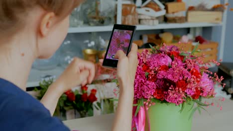 Woman-taking-photo-of-beautiful-bouquet-with-smartphone.