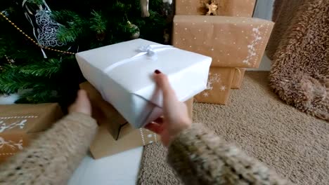 Woman-wraps-ribbon-on-christmas-gift-box