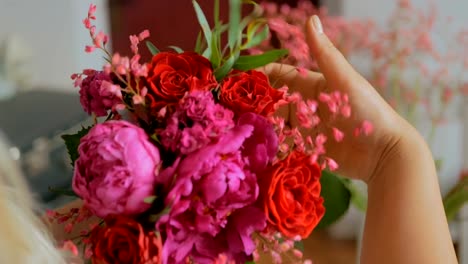 Professional-florist-making-beautiful-bouquet-at-flower-store