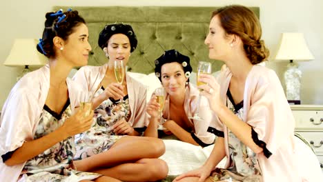 Four-women-toasting-champagne-glasses-on-the-bed-4K-4k