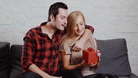 young-man-gives-a-gift-to-a-girl-on-the-couch