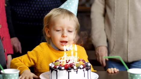 Aufgeregt,-kleiner-Junge-bläst-Kerzen-zum-Geburtstag