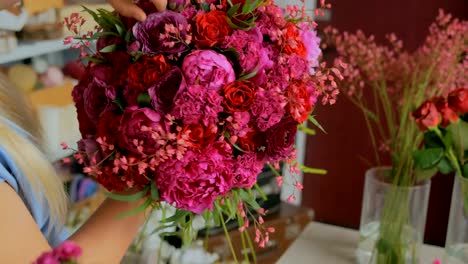 Professional-florist-making-beautiful-bouquet-at-flower-store