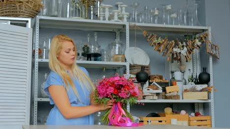 Professional-florist-holding-and-checking-bouquet-at-studio