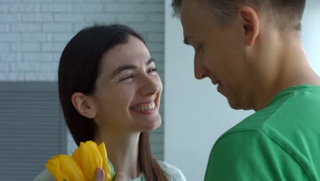 Lovely-woman-enjoying-smell-of-flowers-given-by-man