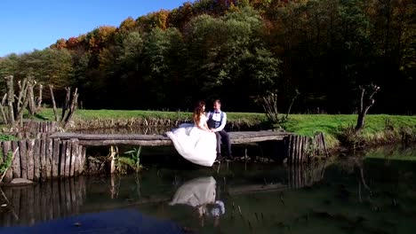 Las-novias-se-sientan-cerca-del-lago-en-un-pequeño-puente-en-el-Parque