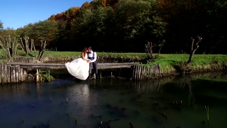 Las-novias-se-sientan-cerca-del-lago-en-un-pequeño-puente-en-el-Parque