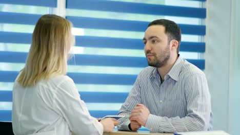 Male-patient-with-sore-throat-getting-doctor-appointment-at-the-reception