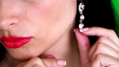 close-up,-part-of-a-female-face,-female-hands-dress-a-beautiful-earring-with-shiny-sparkling-stones