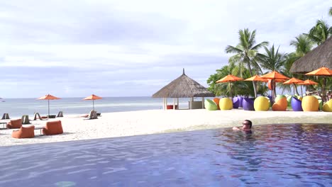 Un-hombre-en-la-piscina-al-aire-libre-a-orillas-del-mar