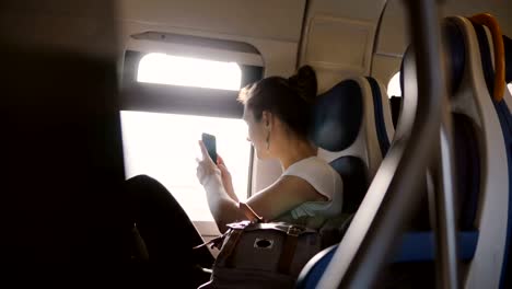 Hermosa-chica-caucásica-feliz-tomando-una-foto-de-smartphone-del-móvil-de-tren-ventana-y-publicar-en-una-red-social