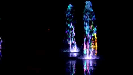 Fuente-de-agua-de-la-noche-bailando-con-fondo-de-imágenes-de-blur-multicolores-luces-de-color,-planos,-profundidad-de-campo,-59,94-fps