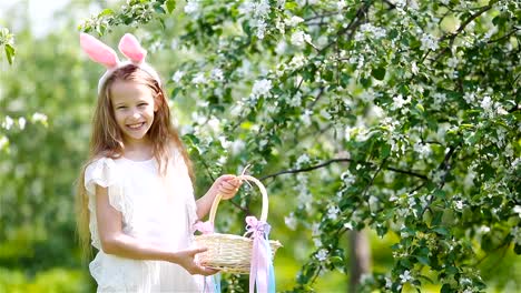 Entzückende-kleine-Mädchen-in-blühender-Apfelgarten-an-schönen-Frühlingstag