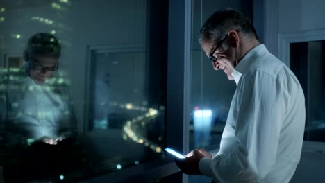 Happy-Manager-Using-Smartphone-In-Dark-Office-At-Night