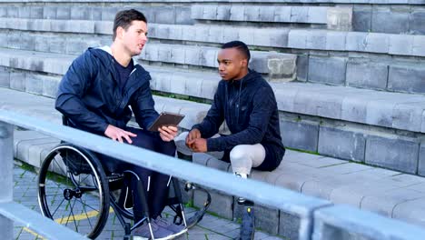 Two-disabled-athletics-discussing-over-digital-tablet-4k