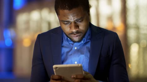 Good-looking-African-Man-Typing-on-Tablet