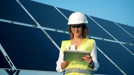 Woman-stands-near-solar-panels-and-smiles,-close-up.