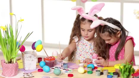 Happy-children-wearing-bunny-ears-painting-eggs-on-Easter-day.