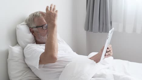 Grandfather-or-senior-man-using-tablet-technology-and-cheer-up-on-bed