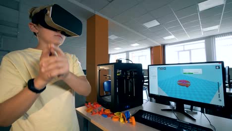 Young-boy-using-virtual-reality-headset-for-engineering-robot-part-printed-on-3D-printer.