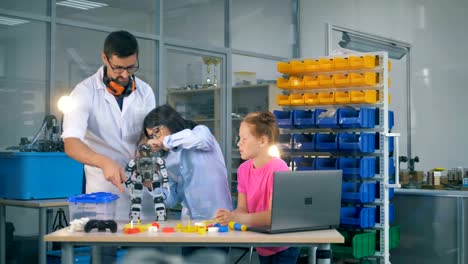 Ingenieur-lehrt-innovative-Robotertechnologien-Gruppe-von-Kindern-im-Science-Club.