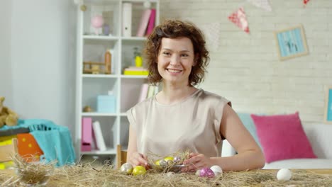 Beautiful-Woman-Smiling-for-Camera-and-Preparing-Easter-Eggs