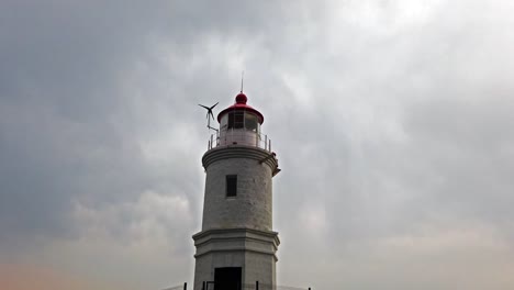 Landscape-with-a-white-lighthouse-against-a-cloudy-sky.