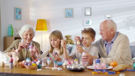 Abuelos-y-nietos-pintando-huevos-y-sonriendo