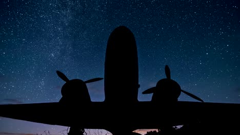 Sterne-mit-Milchstraße-bewegen-sich-über-Flugzeug-Silhouette-von-Militärflugzeugen-in-Sternenhimmel-Astronomie-Zeitraffer