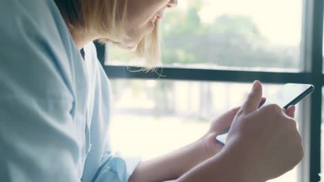 Mujer-freelance-de-negocios-asiática-usando-un-teléfono-inteligente-para-hablar,-leer-y-enviar-mensajes-de-texto-mientras-está-sentado-en-la-mesa-en-la-cafetería.-Estilo-de-vida-inteligente-mujeres-hermosas-trabajando-en-los-conceptos-de-cafetería.