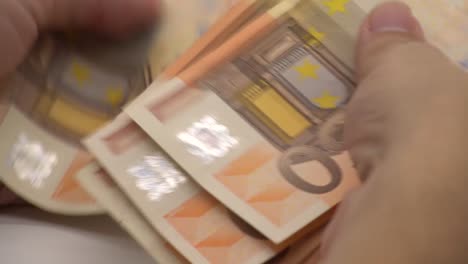 4K-Cerrar-manos-contando-billetes-de-euros-de-cincuenta-y-cien.-Contar-dinero