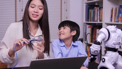 Teacher-teaching-little-boy-about-progarming-robot-by-computer.-Boy-having-training-class-to-develop-hardware-with-teacher.